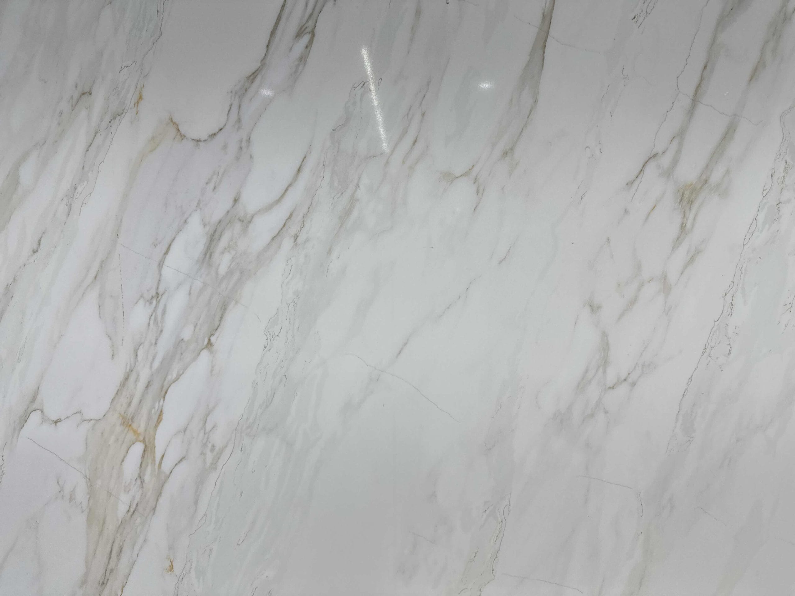 White marble surface with gray and light brown veining patterns throughout.