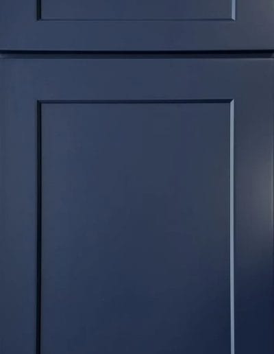 A navy blue shaker-style cabinet door with simple rectangular panels and clean edges.