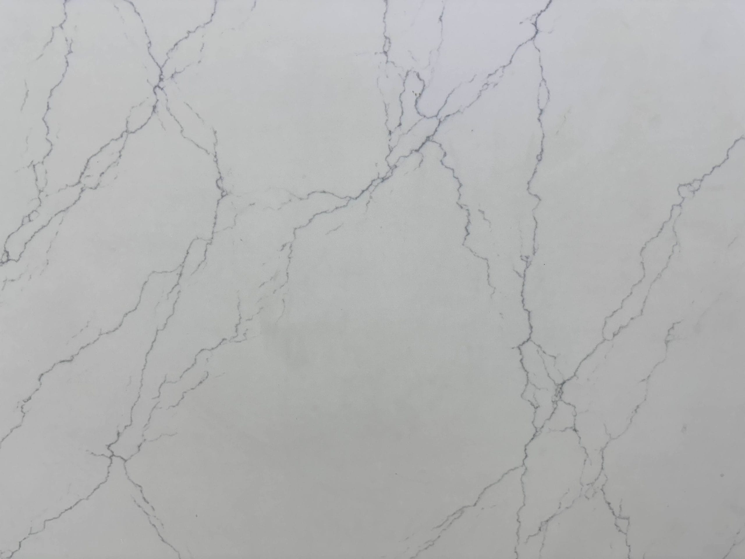 White marble surface with light gray veining in a natural, irregular pattern.